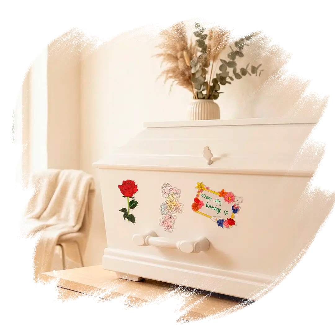 Tre farvelagte blomstrende mindemærkater sat på en kiste. 