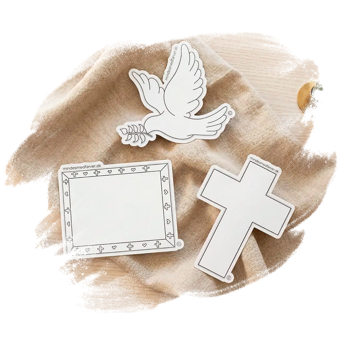 Tre store klistermærker som ligger på et bord. Viser en due, et kors og en ramme.