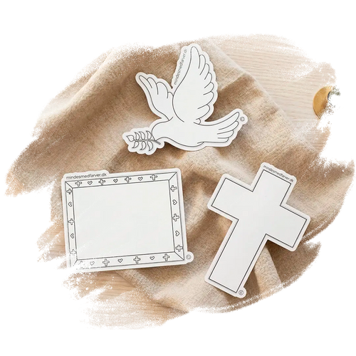 Tre store klistermærker som ligger på et bord. Viser en due, et kors og en ramme.