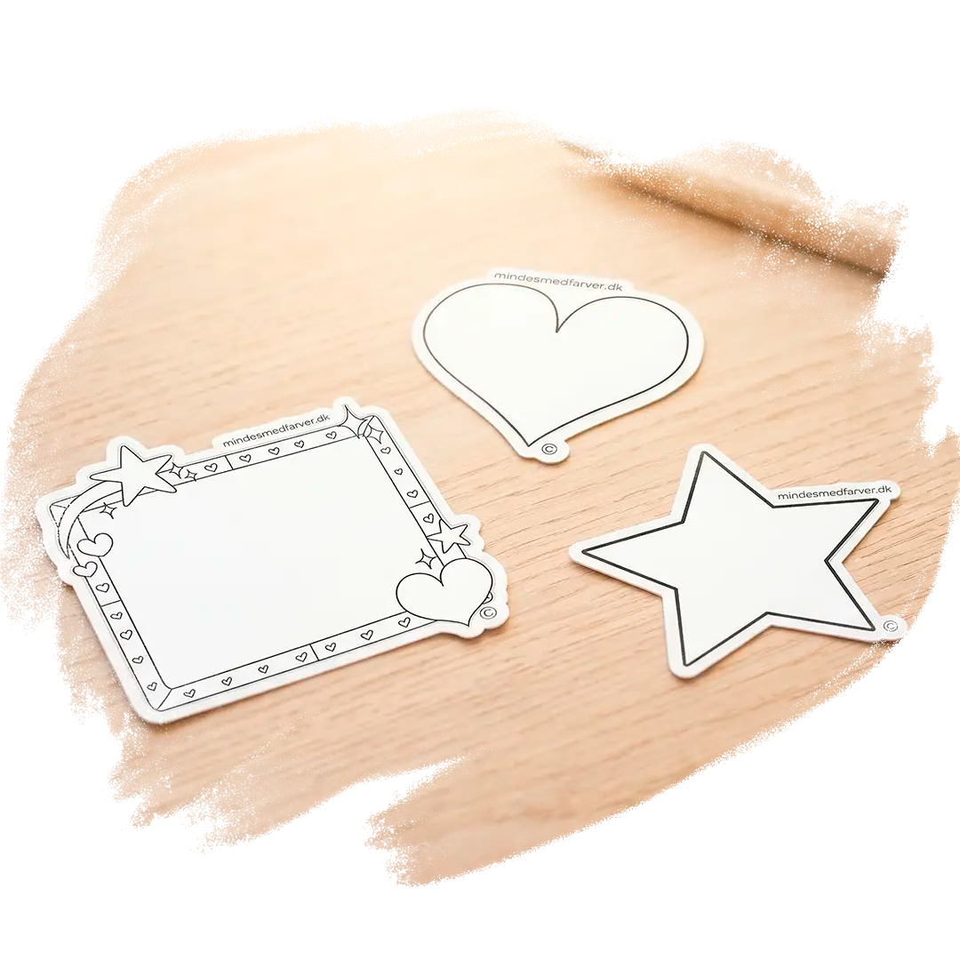Tre store klistermærker som ligger på et bord. Viser en stjerne, et hjerte og en ramme.