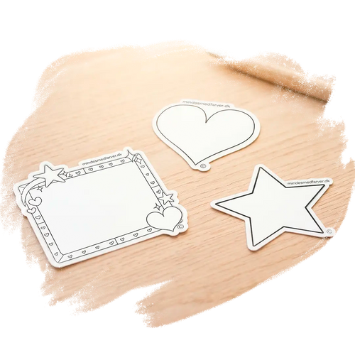Tre store klistermærker som ligger på et bord. Viser en stjerne, et hjerte og en ramme.