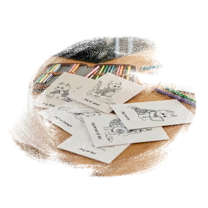 Seks forskellige tegn og snak kort liggende på et bord med farveblyanter. 